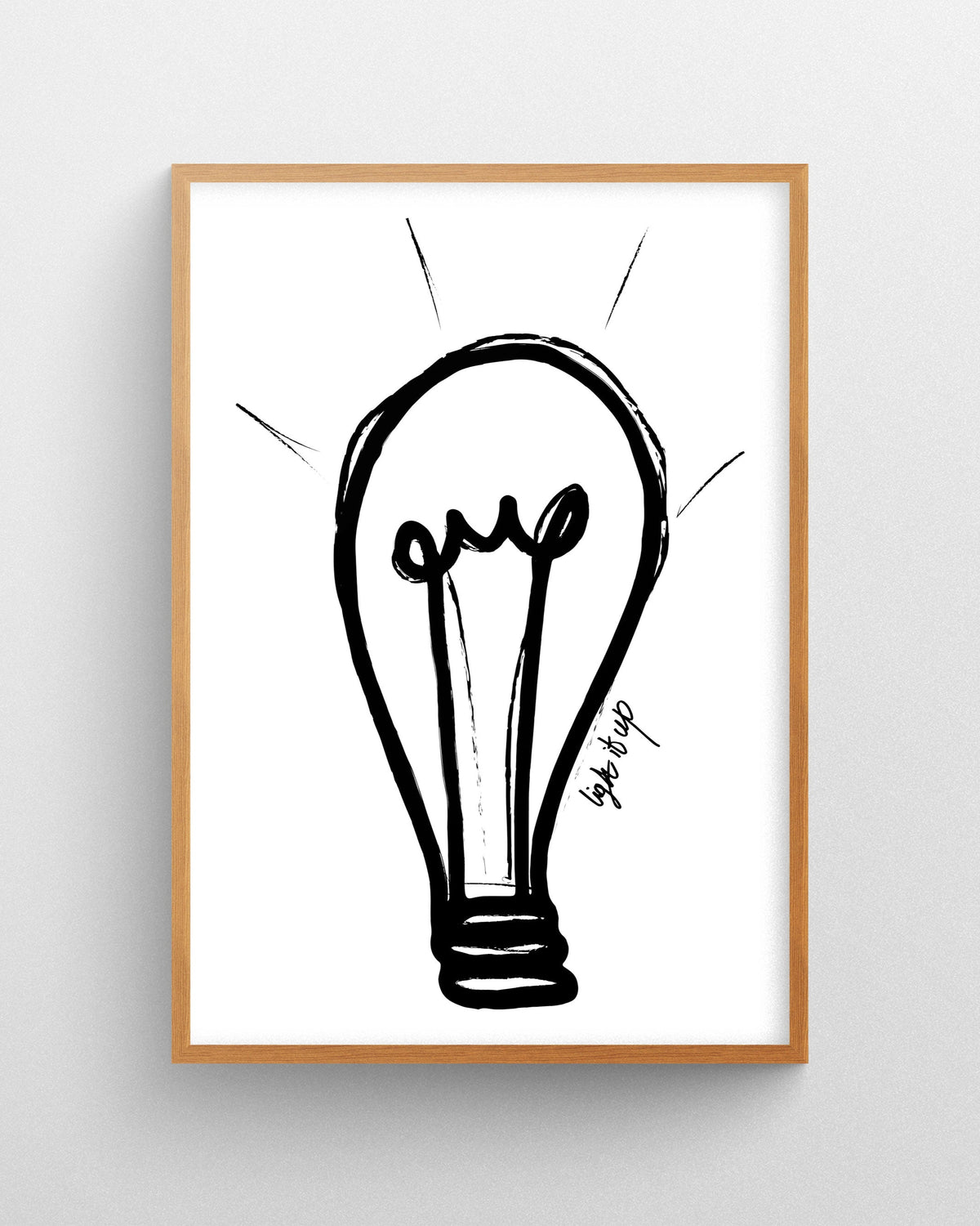 Minimalist light bulb illustration in black line art on a white background displayed in a natural wood frame.